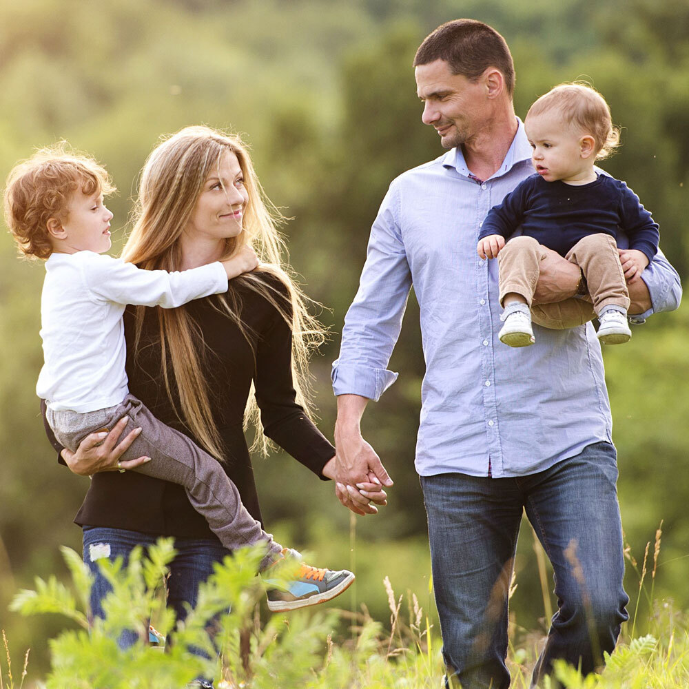 Photo of Family of Four Taking a Walk Down a Path and Holding Hands after Visiting One Eleven Dental Care