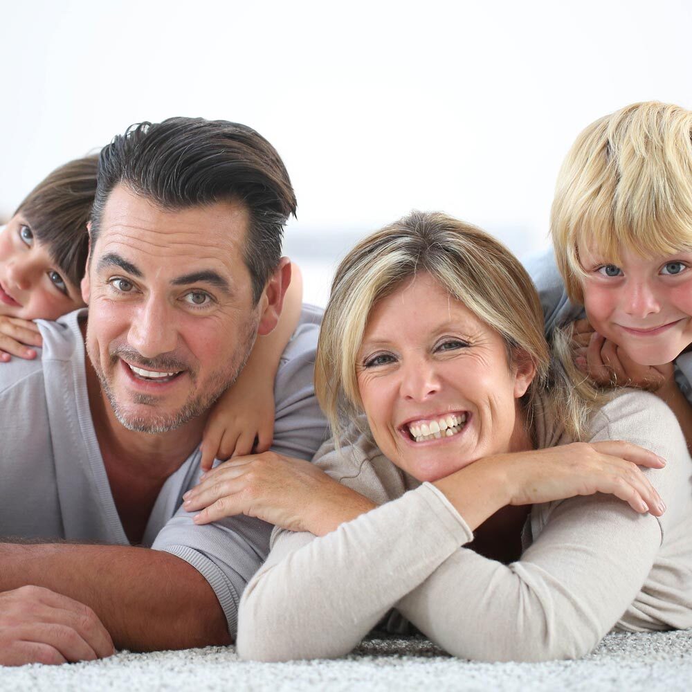Portrait of Family Looking into the Camera and Smiling Playfully after Visiting One Eleven Dental Care