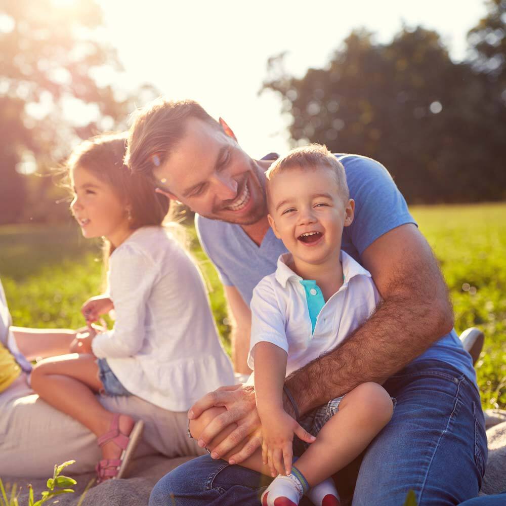 Photo of Loving Family Having a Picnic Outside and Enjoying the Summer after Visiting One Eleven Dental Care
