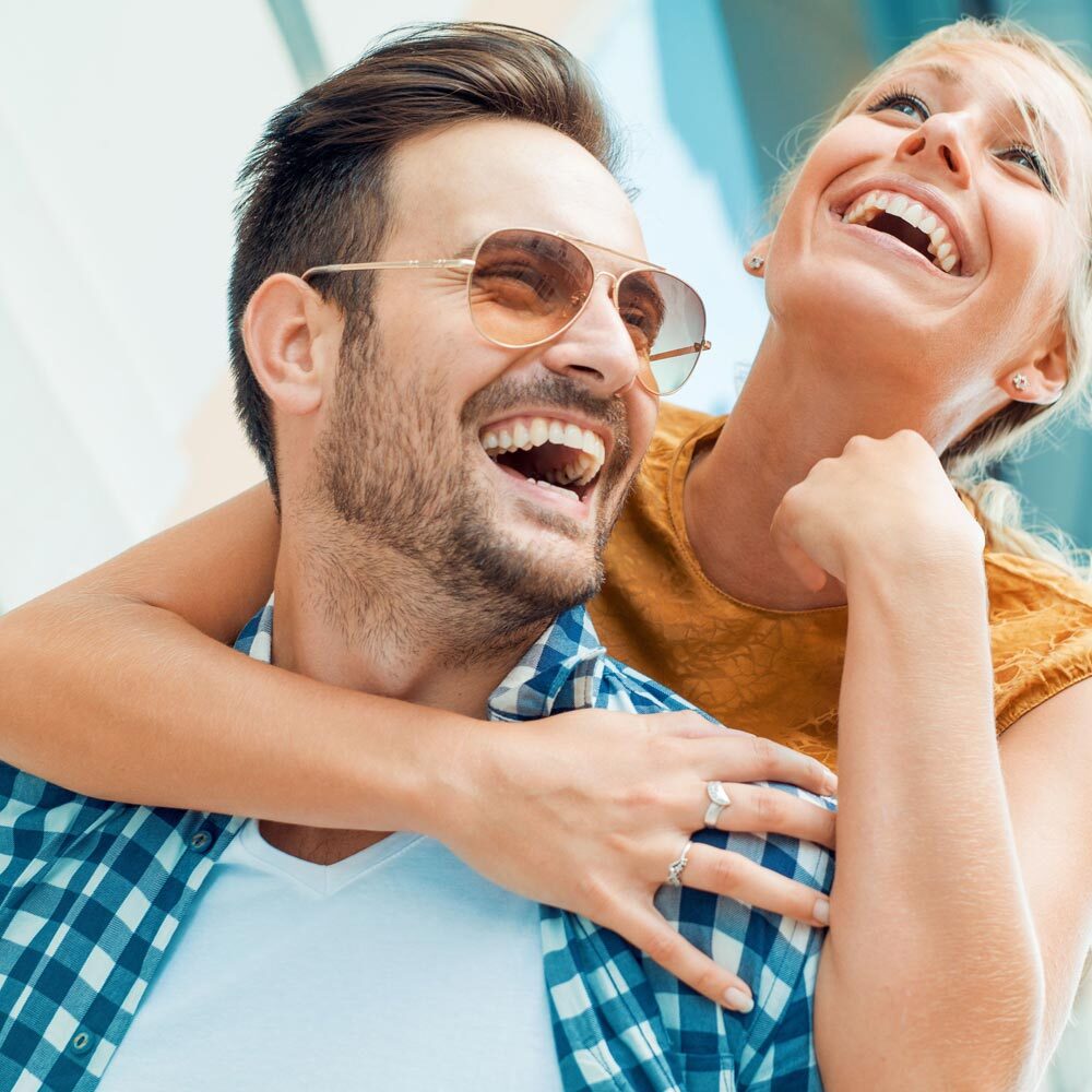 Portrait of Smiling Couple Hugging and Smiling in Town after Visiting One Eleven Dental Care