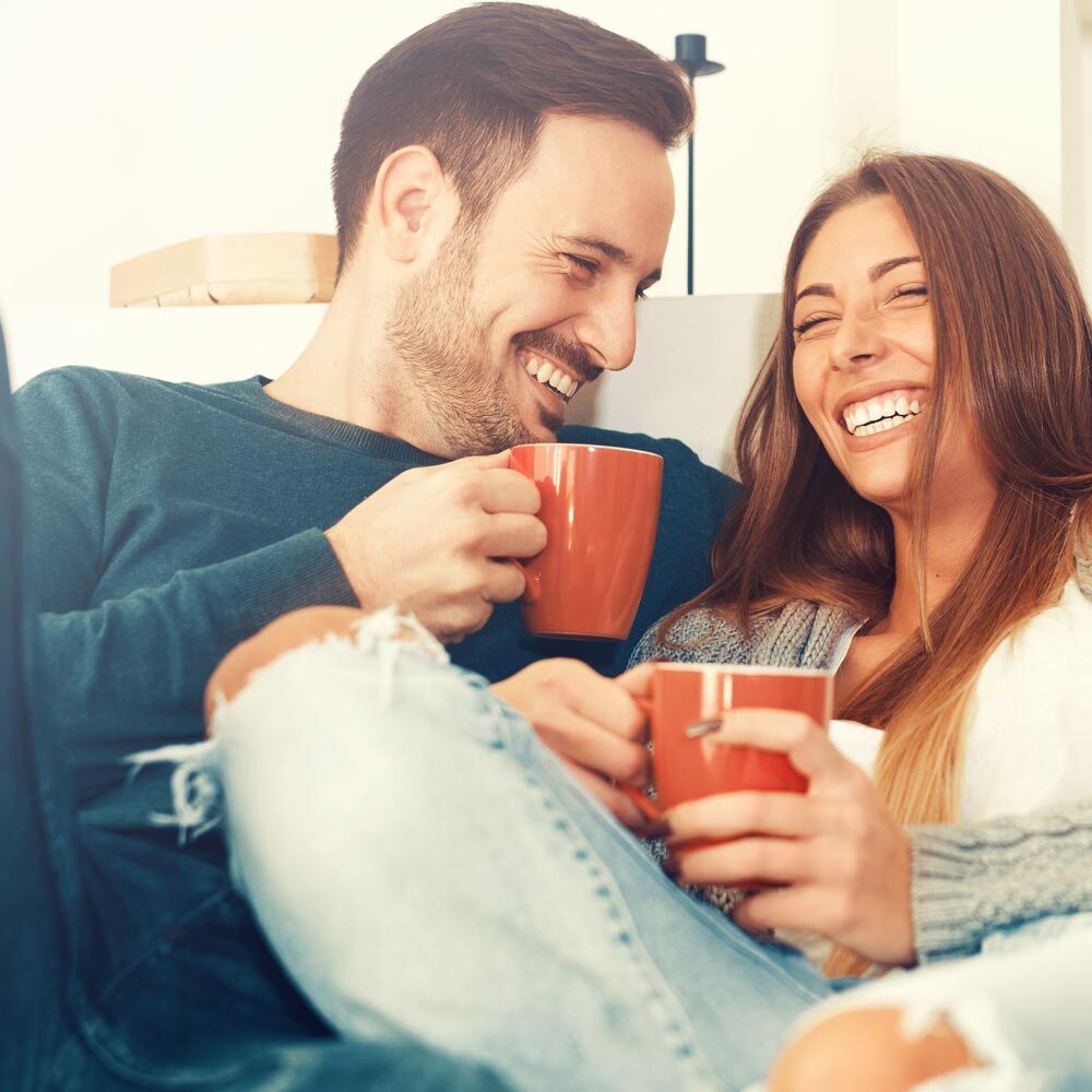 Portrait of Couple Chilling on the Couch and Enjoying a Cup of Coffee after Visiting One Eleven Dental Care