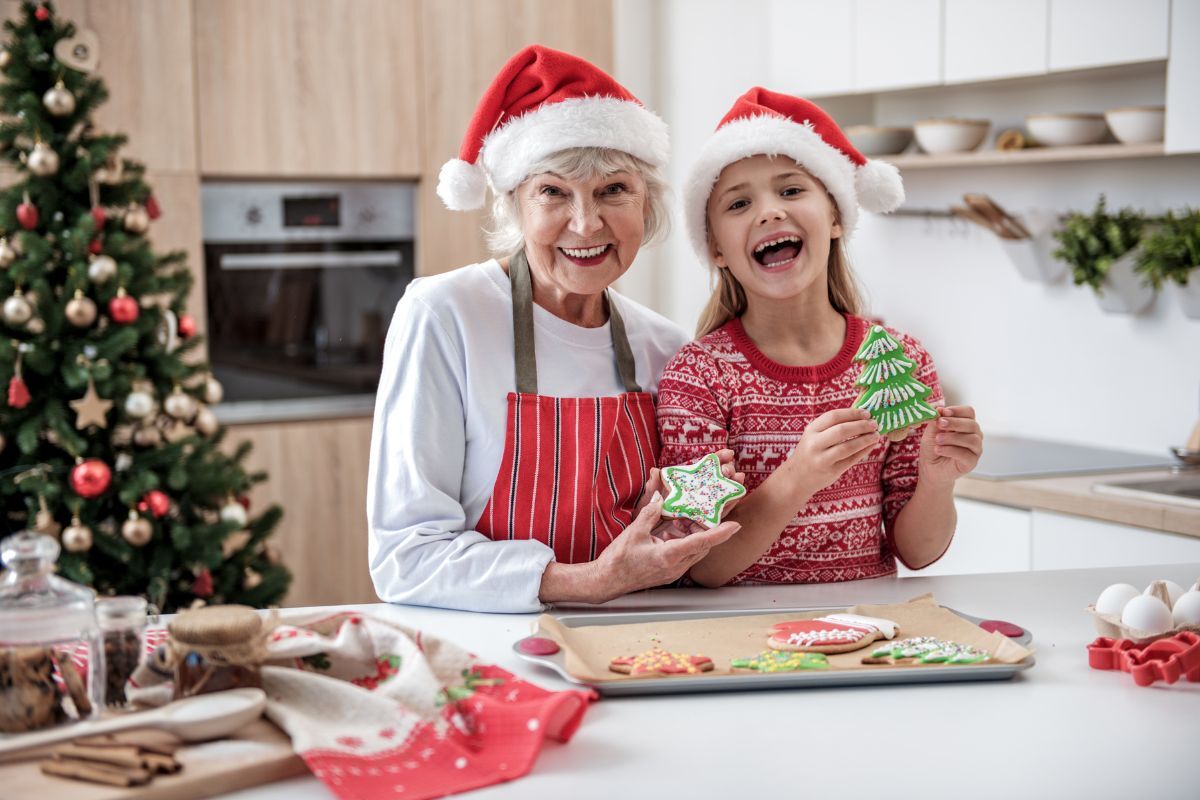 Christmas Treats that are Good for Your Teeth Grandmother and granddaughter baking tooth-friendly Christmas cookies together in a bright kitchen.