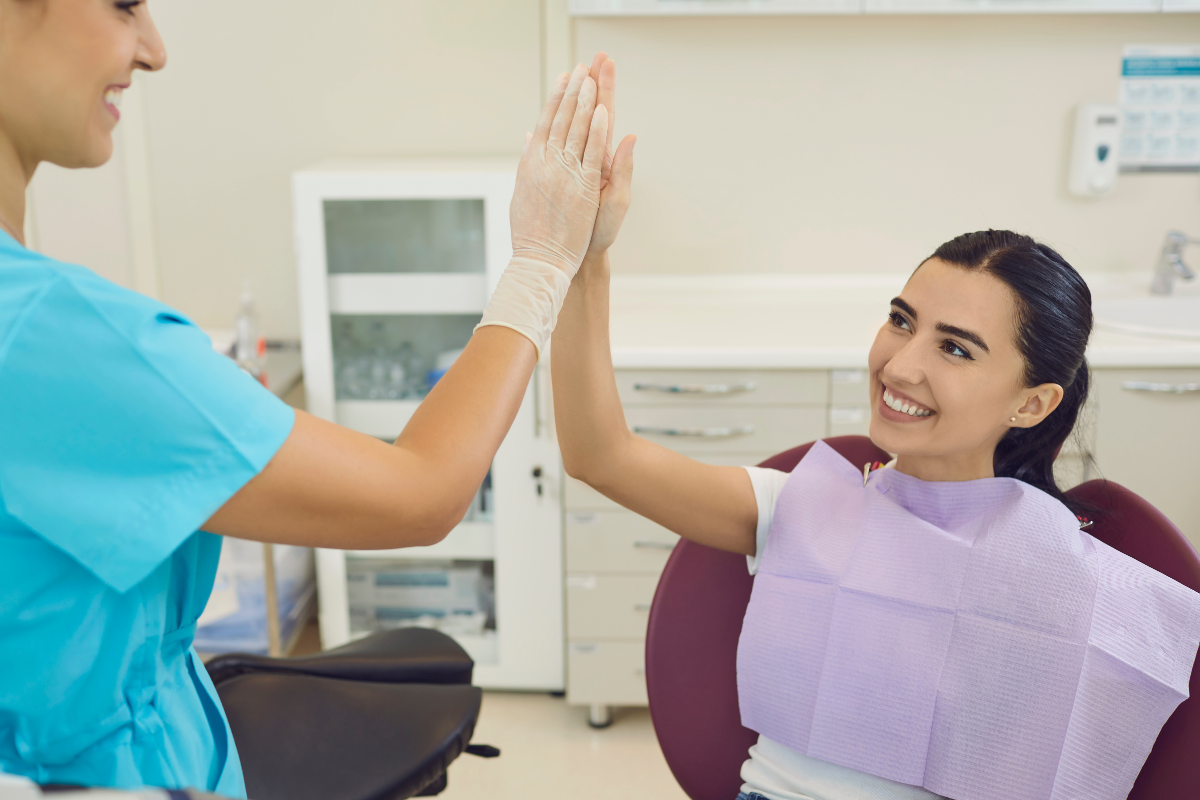 How to Choose the Best Dentist for Your Family in Bixby, OK Dental professional and patient giving a high five in a modern dental office.