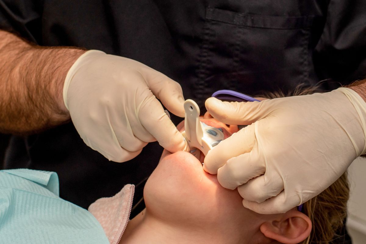 Dentist examining patient's teeth during composite bonding procedure with dental instruments.