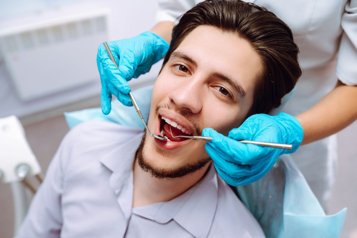 Dentist examining patient's teeth during first dental visit appointment.